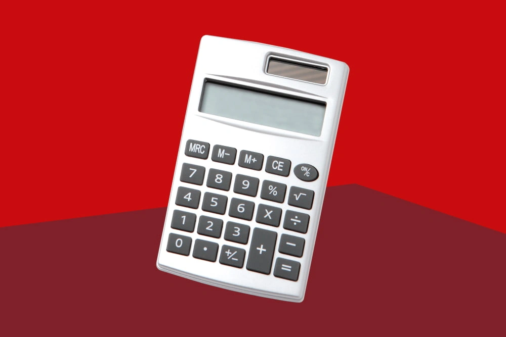 Ein silberner Taschenrechner vor rotem Hintergrund.